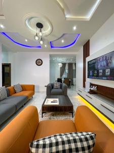 a living room with couches and a flat screen tv at Sparkles Apartments in Abuja