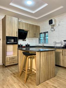 a kitchen with wooden cabinets and a island with a counter top at Sparkles Apartments in Abuja