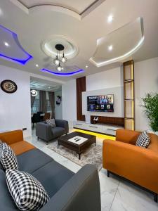 a living room with couches and a tv at Sparkles Apartments in Abuja