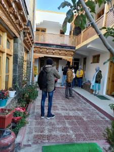 Himalayan Regal House في Deskit: شخص يحمل حقيبة ظهر يقف خارج المبنى