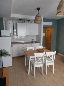 - une cuisine avec une table en bois et des placards blancs dans l'établissement DIVINA GUEST HOUSE, à Manzanares