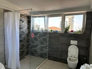 a bathroom with a shower and a toilet and a window at 38 Apartment 1 in Pristina