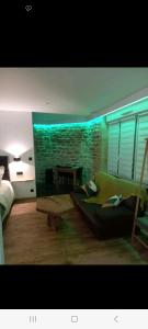 a living room with a green couch and a brick wall at Romantique room in Charleville-Mézières