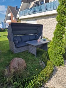 Haus der Erholung App 2 في Lotte: أريكة زرقاء وطاولة في الفناء