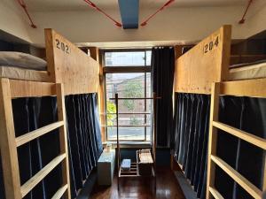 a room with three bunk beds and a window at Hostel Bedgasm in Tokyo