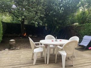 un tavolo bianco e sedie su una terrazza in legno di Lovely studio 35 m2 with garden. 2/4 people a Le Chesnay