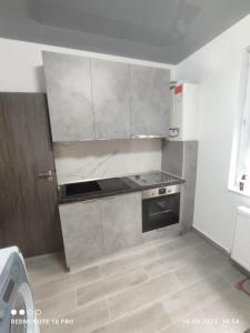a kitchen with white cabinets and a stove at Sipotul Apelor in Domneşti