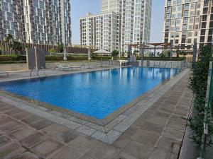 a large swimming pool in a city with tall buildings at Dubai Hills Park Heights 2 in Dubai