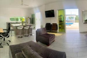 a living room with a couch and a kitchen at Casa campestre californiana con piscina privada in El Brasil