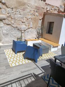 een patio met blauwe stoelen, een tafel en een muur bij LOS PEPINOS ( mi lugar favorito ) in Zamora