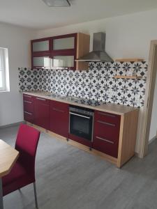 een keuken met rode kasten en zwarte en witte tegels bij Wohnung Monteurswohnung in Bad Salzschlirf in Bad Salzschlirf