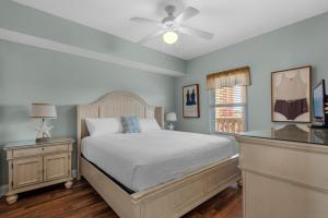 Schlafzimmer mit einem Bett und einem Deckenventilator in der Unterkunft Calypso 1-608 East in Panama City Beach