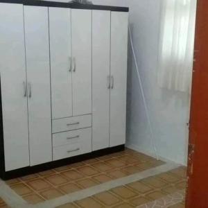 a kitchen with white cabinets and a tile floor at Chacara lima in Pedro de Toledo