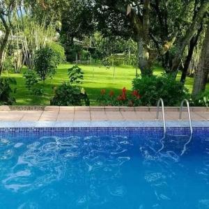 a large blue swimming pool in a yard at Chacara lima in Pedro de Toledo