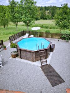 a swimming pool with a chair next to a fence at Les Verges Gites in Exideuil