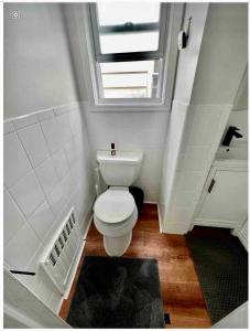 a bathroom with a white toilet and a window at 8-A Diamond in Yonkers, NY in Yonkers
