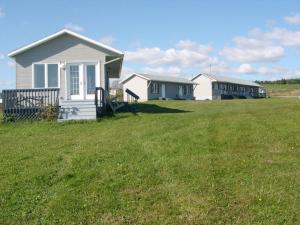 a row of houses in a field of grass at Motel Seal Rock in Perce