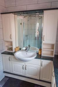 uma casa de banho com um lavatório e um espelho grande em Comfort at Keldy em Tettenhall