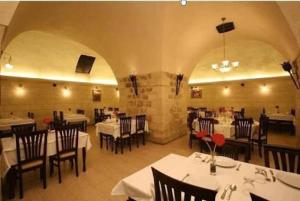 a dining room with white tables and chairs in a restaurant at Mardin Konak Osmanlı in Mardin