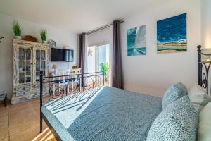 a bedroom with a bed with a blue bedspread at Sunset Escape in Playa Paraiso