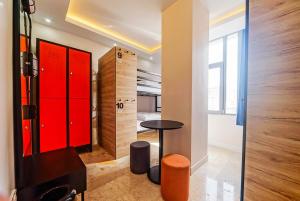 Pokój z czerwonymi szafkami oraz stołem i stołkiem w obiekcie Manu Startup House w Stambule