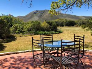 a table and chairs with a view of a field at Klein Paradijs Country Retreat in Pearly Beach