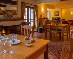 a living room with a table and a fireplace at Klein Paradijs Country Retreat in Pearly Beach