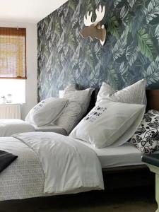 a bedroom with two beds with white pillows and a wallpaper at NUMMER EiNS in Neuötting