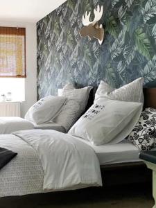 1 dormitorio con 2 camas con almohadas blancas y papel pintado en NUMMER EiNS, en Neuötting
