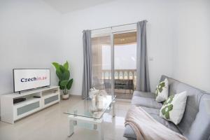 a living room with a couch and a tv at Serene Studio & Sea View & Brand New Listing in Ras al Khaimah