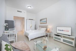 Ein weißes Zimmer mit einem Bett und einem Wohnzimmer. in der Unterkunft Serene Studio & Sea View & Brand New Listing in Ras al Khaimah