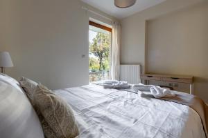 Cama blanca en habitación con ventana en Orminia ground level, 