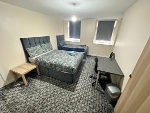 a small room with a bed and a desk at Rangers GuestHouse in Glasgow