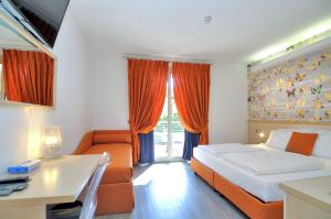 a bedroom with a bed and a couch and a desk at Eco Hotel Cleofe in Caorle +37 photos