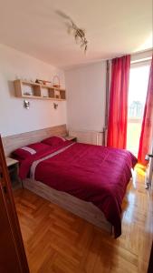 LazarevacにあるStan na dan S8のベッドルーム1室(大型ベッド1台、赤い掛け布団付)