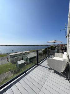 - une terrasse avec un canapé, un parasol et l'eau dans l'établissement Lake View 92, à Millom