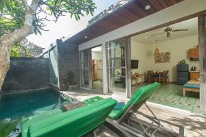 une terrasse avec une piscine et des chaises à côté d'une maison dans l'établissement Sari Dana Villas, à anur