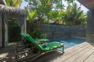 a pool with a chaise lounger and a swimming pool at Sari Dana Villas in Sanur