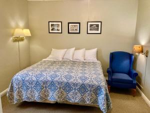 a bedroom with a bed and a blue chair at Garden Grove Retreat & Lodging near Pictured Rocks, Fayette, Trails in Garden