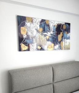 un dipinto appeso a un muro sopra un divano di Poly's Home 2 a Ioannina