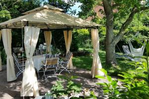 a gazebo with chairs and a table in a yard at Ferienwohnung Madlein in Rehna