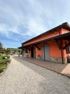 una casa rossa con una strada sterrata accanto di La Perla di Assisi ad Assisi