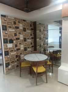 a table and chairs in a room with a wall of pictures at City Beautiful Home One room Suite in Panchkula
