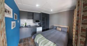 a small bedroom with a bed and a kitchen at Matusadona Guest Lodge in Hillcrest