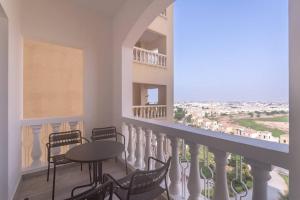 balcón con mesa, sillas y vistas en Luxurious Golf View & 1BD & Brand New Listing en Ras al-Jaima