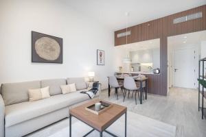 een woonkamer met een bank en een tafel bij Luxurious Golf View & 1BD & Brand New Listing in Ras al Khaimah