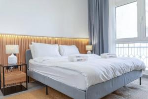um quarto com uma grande cama branca e uma cabeceira em madeira em Luxurious Golf View & 1BD & Brand New Listing em Ras al-Khaimah