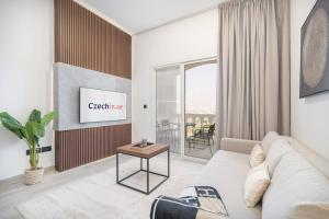 een woonkamer met een witte bank en een tafel bij Luxurious Golf View & 1BD & Brand New Listing in Ras al Khaimah