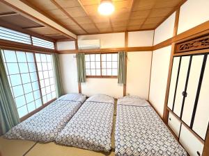 duas camas num quarto com duas janelas em 浜町小院别馆 em Takamatsu