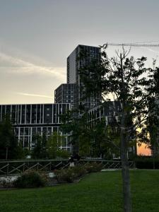 a tree in a park in front of a building at Sweet Home in Milano smart district in Milan